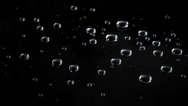 Scattered silver water droplets catching light on a pure black glossy surface, minimal and elegant, original AI dark AMOLED wallpaper